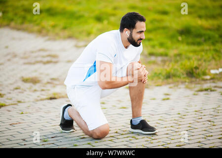 Beinverletzung. Männliche Athleten leiden unter Schmerzen im Bein während des Trainings im Freien Stockfoto