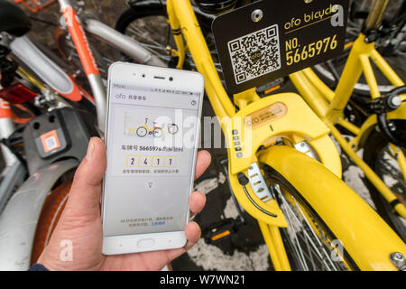 ---- Handy Benutzer verwendet die Anwendung der Chinesischen bike-sharing Service ofo auf seinem Smartphone ein Fahrrad in Shanghai, China, 10. April 2017 zu mieten. Stockfoto