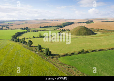 Silbury Hill, Nr Avebury, Wiltshire, UK. 6. August 2019. Die alten künstlichen Erdhügel Silbury Hill taucht in der Ferne die Ernte erfolgt i Stockfoto