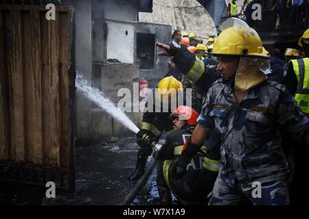 Kathmandu, Nepal. 7 Aug, 2019. Nepalesische Sicherheitskräfte und Feuerwehrmänner begießen, einen Brand in einem Gebäude in Kathmandu, Nepal, am Aug 7, 2019. Es wurden keine menschlichen Opfer in der Vorfall gemeldet. Credit: Sulav Shrestha/Xinhua Quelle: Xinhua/Alamy leben Nachrichten Stockfoto