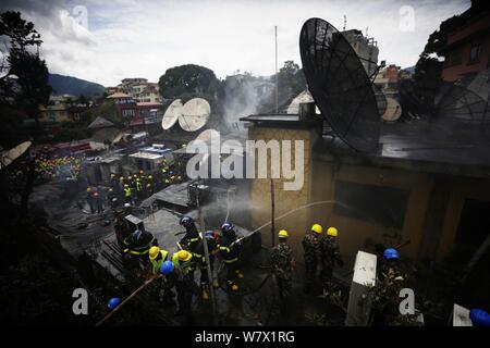 Kathmandu, Nepal. 7 Aug, 2019. Nepalesische Sicherheitskräfte und Feuerwehrmänner begießen, einen Brand in einem Gebäude in Kathmandu, Nepal, am Aug 7, 2019. Es wurden keine menschlichen Opfer in der Vorfall gemeldet. Credit: Sulav Shrestha/Xinhua Quelle: Xinhua/Alamy leben Nachrichten Stockfoto