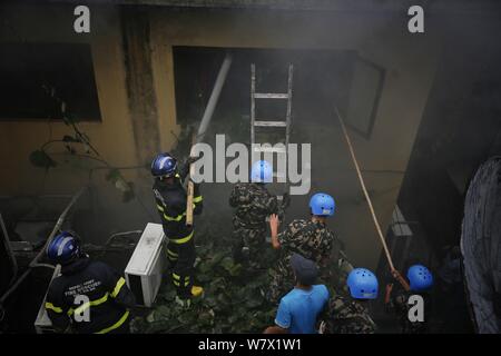 Kathmandu, Nepal. 7 Aug, 2019. Nepalesische Sicherheitskräfte und Feuerwehrmänner begießen, einen Brand in einem Gebäude in Kathmandu, Nepal, am Aug 7, 2019. Es wurden keine menschlichen Opfer in der Vorfall gemeldet. Credit: Sulav Shrestha/Xinhua Quelle: Xinhua/Alamy leben Nachrichten Stockfoto