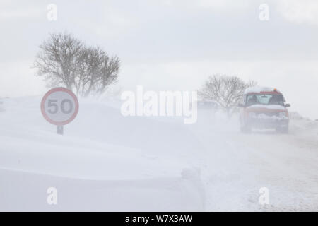 Große Schneeverwehungen überschwemmen Landstraße, Peak District National Park, Deryshire, UK. März 2013. Stockfoto