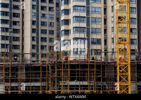 ------ Chinesische Wanderarbeiter ein hohes Gebäude auf der Baustelle eine Wohn- Projekt in Yichang city konstruieren, c Stockfoto