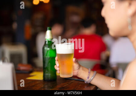 Womans Hand ein Glas kaltes Bier im Urlaub. Stockfoto