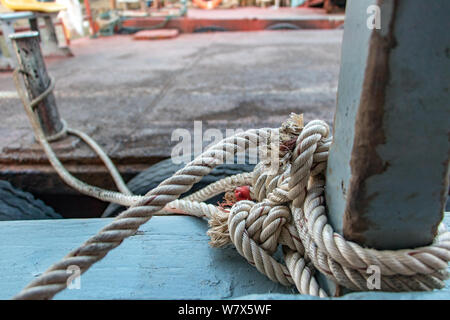 Ein Boot am Hafen, in der Nähe des Seil gebunden bei Poller. Boot vertäut an der Pier. Stockfoto