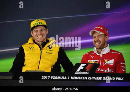 Deutschen F1-Fahrer Nico Hulkenberg von Renault, Links, und die Deutsche Formel-1-Fahrer Sebastian Vettel der Scuderia Ferrari eine Pressekonferenz vor teilnehmen Stockfoto