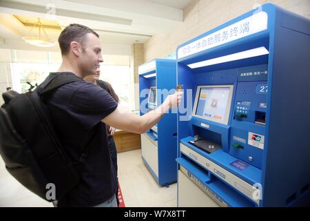 Australische Mann Tim Clancy nimmt seinen amerikanischen Freund smart Krankenhaus durch mobile Payment an einem Krankenhaus in Hangzhou City zu erleben, der East China Z Stockfoto