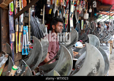 Dhaka, Bangladesch - Juli 07, 2019: Schmiede Shop bei karwan Bazar in Dhaka haben hart gearbeitet, Messer, Hackmesser, Macheten und anderen scharfen zu machen Stockfoto