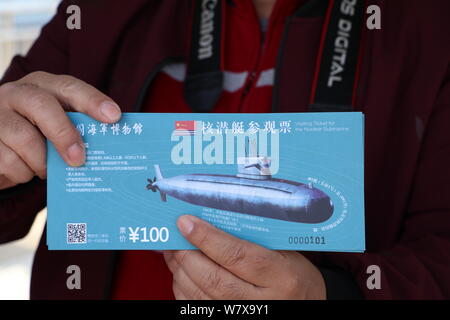 Ein Tourist zeigt Besuch Tickets für einen stillgelegten Typ-091 Atom-U-Boot an der Chinesischen Marine Museum in Qingdao Stadt,'s East China Shandong pro Stockfoto