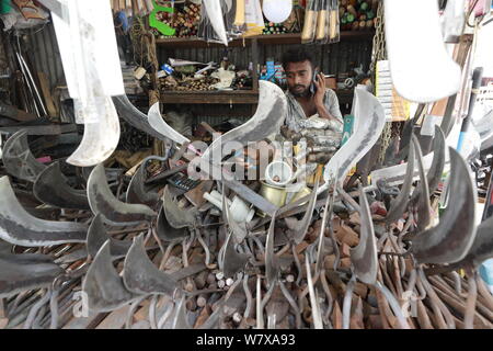 Dhaka, Bangladesch - Juli 07, 2019: Schmiede Shop bei karwan Bazar in Dhaka haben hart gearbeitet, Messer, Hackmesser, Macheten und anderen scharfen zu machen Stockfoto