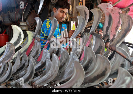 Dhaka, Bangladesch - Juli 07, 2019: Schmiede Shop bei karwan Bazar in Dhaka haben hart gearbeitet, Messer, Hackmesser, Macheten und anderen scharfen zu machen Stockfoto