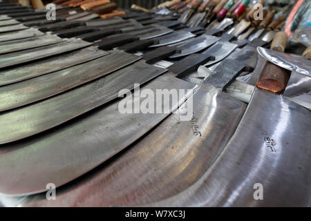 Dhaka, Bangladesch - Juli 07, 2019: Schmiede Shop bei karwan Bazar in Dhaka haben hart gearbeitet, Messer, Hackmesser, Macheten und anderen scharfen zu machen Stockfoto