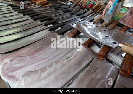 Dhaka, Bangladesch - Juli 07, 2019: Schmiede Shop bei karwan Bazar in Dhaka haben hart gearbeitet, Messer, Hackmesser, Macheten und anderen scharfen zu machen Stockfoto