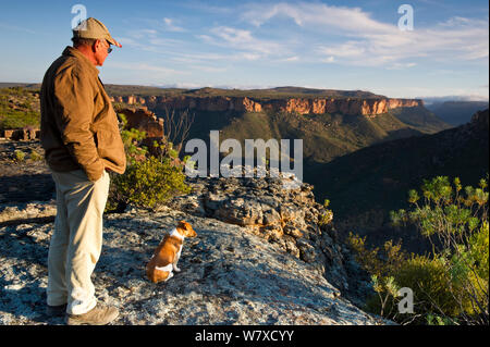 Landwirt Willem Van Wyk und sein Hund, über Oorlogskloof Canyon suchen. Tief in die Schlucht ist eine der beiden bekannten Brutstätten für den Gefährdeten Clanwilliam sandfish (Labeo seeberi). Papkuilsfontein Farm, Northern Cape, Südafrika. August 2013. Stockfoto