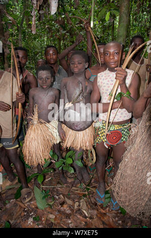 Mbuti pygmy Einleitung Jagd, mit zwei Jungen in traditionellen Blau Body Paint und Stroh Rock. Eine junge hält Fang von Blue Duiker (Philantomba monticola). Ituri Rainforest, Demokratische Republik Kongo, Afrika, November 2011. Stockfoto