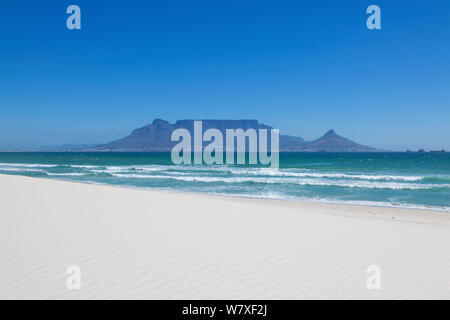 Unberührten weißen Sandstrand mit dem Tafelberg über unter einem klaren blauen Himmel. Bloubergstrand, Kapstadt, Südafrika. November 2011. Stockfoto