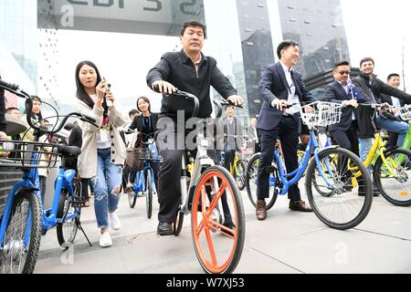 Luo Qiang, front, Bürgermeister von Chengdu, und andere Regierungsvertreter und Geschäftsleute fahren Fahrräder der Chinesischen bike-sharing Services außerhalb einer u-STA Stockfoto