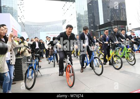 Luo Qiang, front, Bürgermeister von Chengdu, und andere Regierungsvertreter und Geschäftsleute fahren Fahrräder der Chinesischen bike-sharing Services außerhalb einer u-STA Stockfoto