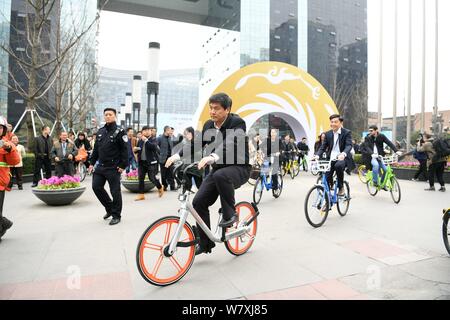 Luo Qiang, front, Bürgermeister von Chengdu, und andere Regierungsvertreter und Geschäftsleute fahren Fahrräder der Chinesischen bike-sharing Services außerhalb einer u-STA Stockfoto