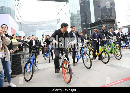 Luo Qiang, front, Bürgermeister von Chengdu, und andere Regierungsvertreter und Geschäftsleute fahren Fahrräder der Chinesischen bike-sharing Services außerhalb einer u-STA Stockfoto