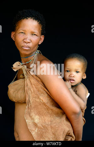 Portrait von naro San Frau mit Baby, das Tragen der traditionellen duiker Leder Bekleidung, Kalahari, Ghanzi region, Botswana, Afrika. Oktober 2014. Stockfoto