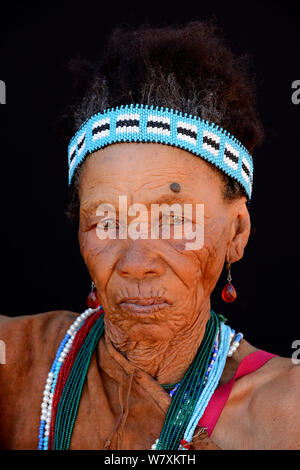 Portrait von naro San Frau in traditioneller Kleidung und Stirnband, Kalahari, Ghanzi region, Botswana, Afrika. Oktober 2014. Stockfoto
