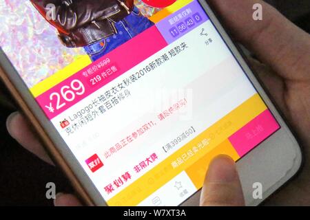 ---- Eine chinesische Mobiltelefon Benutzer verwendet die mobile App von Shopping site Taobao.com der Chinesischen e-commerce Riese Alibaba Group auf Ihrem Smartphone für Sh Stockfoto