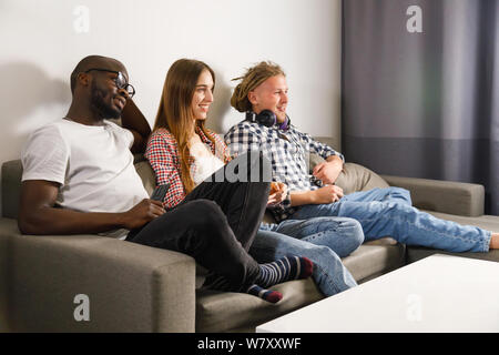 Eine Gruppe von Freunden Spaß haben Fernsehen im Zimmer Stockfoto