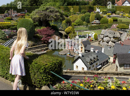 Beaconsfield, Großbritannien - Juni 27., 2019. Ein junges Mädchen Besucher sucht an der Miniatur Häuser in Bekonscot Model Village und Bahnhof, eine beliebte Sehenswürdigkeit Stockfoto