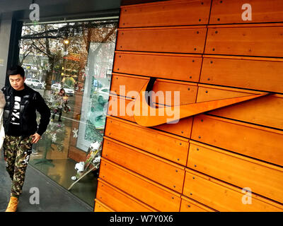 ---- Ein Fußgänger geht hinter einem Nike Sportswear store in Stadt Huaibei, der ostchinesischen Provinz Anhui, 18. Dezember 2016. NIKE war China beschuldigt von Fa Stockfoto