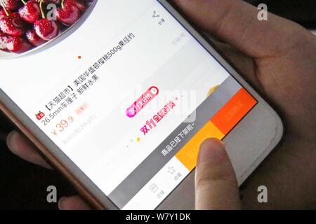 ---- Eine chinesische Mobiltelefon Benutzer verwendet die mobile App von Shopping site Taobao.com der Chinesischen e-commerce Riese Alibaba Group auf Ihrem Smartphone für Sh Stockfoto