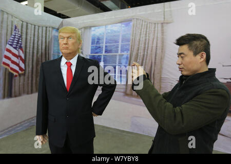 Ein Besucher nimmt Fotos mit einer Wachsfigur des neuen US-Präsidenten Donald Trump auf dem Display während einer Ausstellung in Shenyang City, im Nordosten der chinesischen Provinz Liaoning Stockfoto