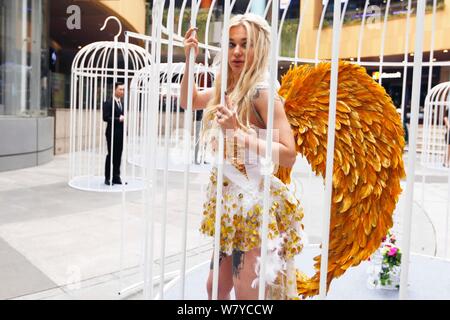 Künstler Flügel tragen sind in riesigen Vogelkäfige während einer Flash Mob für die Bürger zu nennen sich selbst vom Leben in der Stadt am Goldenen Hongqia zu befreien beschränkt Stockfoto