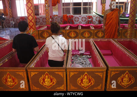 Nonthaburi, Thailand. 5 Aug, 2019. Thais Menschen gesehen in Särgen im Wat Takien Tempel in der Provinz Nonthaburi beten, am Stadtrand von Bangkok. Hunderte gläubige Buddhisten zahlen eine geringe Gebühr in rosa Särge liegen um 9:00 und 13:00 Uhr jeden Tag während der ungewöhnliche tägliche Auferstehung Service, dass Sie glauben, dass Sie Pech waschen und das Leben zu verlängern. Credit: chaiwat Subprasom/SOPA Images/ZUMA Draht/Alamy leben Nachrichten Stockfoto