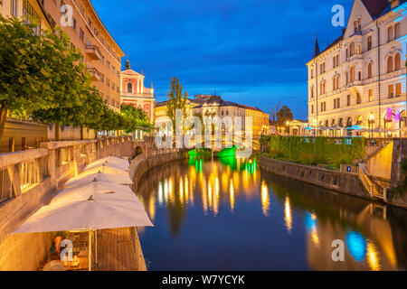 Fluss Ljubljanica riverbank Cafés und der Triple Bridge bei Nacht mit dem rosa Franziskanerkirche ljubljana Slowenien EU Europa Stockfoto