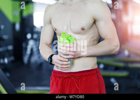 Nahaufnahme der muskulösen Mann in der Turnhalle mit Shaker, geformt Abdominal- Stockfoto