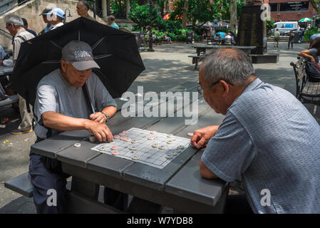 Chinesisches Schach, Blick auf zwei Männer, die Xiangqi spielen, auch als chinesisches Schach bekannt, im Columbus Park im Chinatown-Viertel von New York City, USA Stockfoto