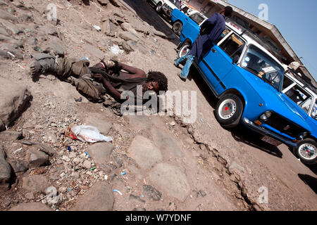 Obdachlose Bettler auf dem Boden liegt neben einem Taxistand in Addis Mercato, Addis Abeba, Äthiopien. Februar 2009 Stockfoto