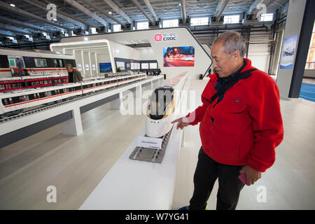 ---- Ein Besucher schaut sich das Trainieren eines Modells auf dem Display am Stand von Crrc während einer Ausstellung in Changchun City, North East China in der Provinz Jilin, 14. Stockfoto