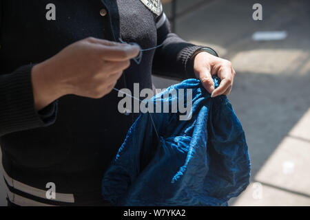 Eine chinesische Frau der Bai ethnische gruppe Bindungen Abschnitte eines blauen Tuch mit String in Dali City, im Südwesten der chinesischen Provinz Yunnan, 24. März 2017. Ch Stockfoto