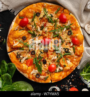 Frische Pizza mit Kirschtomaten auf dunklen Tabelle Stockfoto