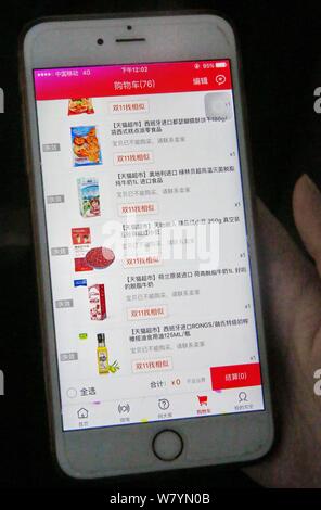 ---- Eine chinesische Mobiltelefon Benutzer verwendet die mobile App von Shopping site Taobao.com der Chinesischen e-commerce Riese Alibaba Group auf Ihrem Smartphone für Sh Stockfoto