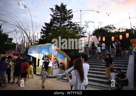 SHIMONOSEKI, Japan - 07 AUGUST: Menschen, die während der jährlichen Suhoutei Iminomiya Festival im Heiligtum genießen Sie am 7. August 2019, in Chofu Shimonoseki, Yamaguchi Präfektur, Japan. Das festival stammt aus dem 2. Jahrhundert, Jahr für Jahr die Menschen vor Ort im Heiligtum compound versammeln sich um einen riesigen Stein mit sehr hohen Bambus Labrums an Ihren Körper während des Spielens durch den Klängen von Gongs und Taiko Trommeln zu gehen. Iminomiya Jinja Gastgeber dieses einzigartige Festival Suhoutei Festival, die Präfektur Yamaguchi als immaterielle Kulturgut bezeichnet wurde. Quelle: Lba Co.Ltd./Alamy leben Nachrichten Stockfoto