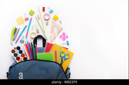 Schule Rucksack mit Schreibwaren innen geöffnet auf Weiß Stockfoto