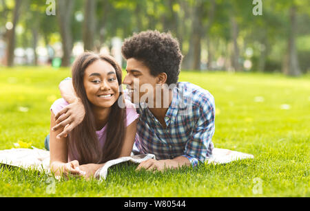Flüstern über die Liebe. Romantische Teenager Festlegung auf Gras im Freien Stockfoto
