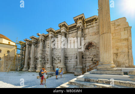 Alte Westwand von Hadrian's Bibliothek in der römischen Agora von Athen Griechenland mit Touristen, die griechischen Ruinen auf einem sonnigen, heissen Sommertag Stockfoto