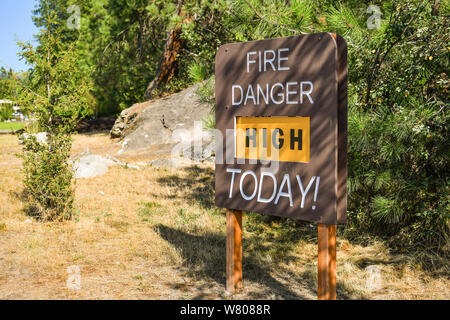 Ein Zeichen auf trockenem Gras auf öffentlichem Land alarmieren, dass Feuer Gefahr heute hoch ist. Stockfoto