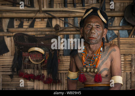 Konyak Nagas tätowiert chief Head Hunter mit traditioneller Ornamentik der Elephant ivory arm Bands und Nashornvogel Kopfschmuck. Nur jemand, der getötet hat und zu einem menschlichen Kopf auf diese Weise tätowiert werden kann. Mon Bezirk. Nagaland, North East India, Oktober 2014. Stockfoto