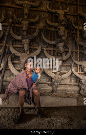 Konyak Nagas Mann mit Enkel, im Haus mit Buffalo Totenköpfen dekoriert, Mon Bezirk, Nagaland, North East India, Oktober 2014. Stockfoto